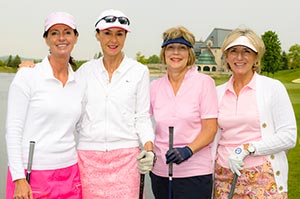 four golfers pose on the course