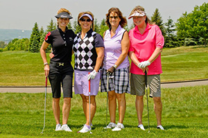 four golfers posing on course
