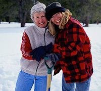 mother and daughter shovelling snow