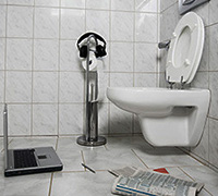 bathroom with laptop and newspaper