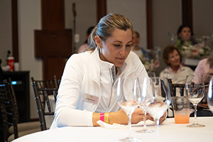 A woman in white golf clothing sits at a banquet table