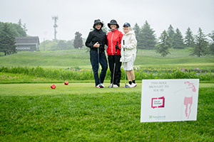 Three golfers stand side by side for a photo