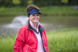 A woman wearing golf clothing smiles