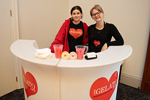 Two women smile at a gelato stand
