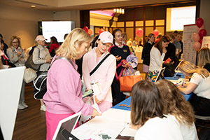 A large group of people wait at a registration table