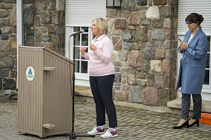 A woman wearing pink speaking into a microphone