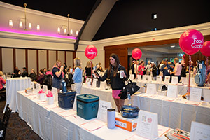 A woman stands at a silent auction table