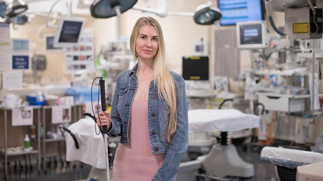 Sarah stands outside a medical room