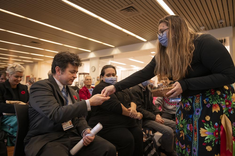 Joanna Diindiisikwe Simmons presenting Indigenous Veteran Jeremy Bullen with a beaded poppy. 