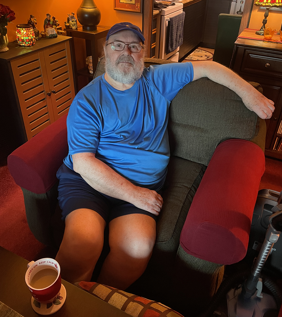 Robin Whyte sits in his living room