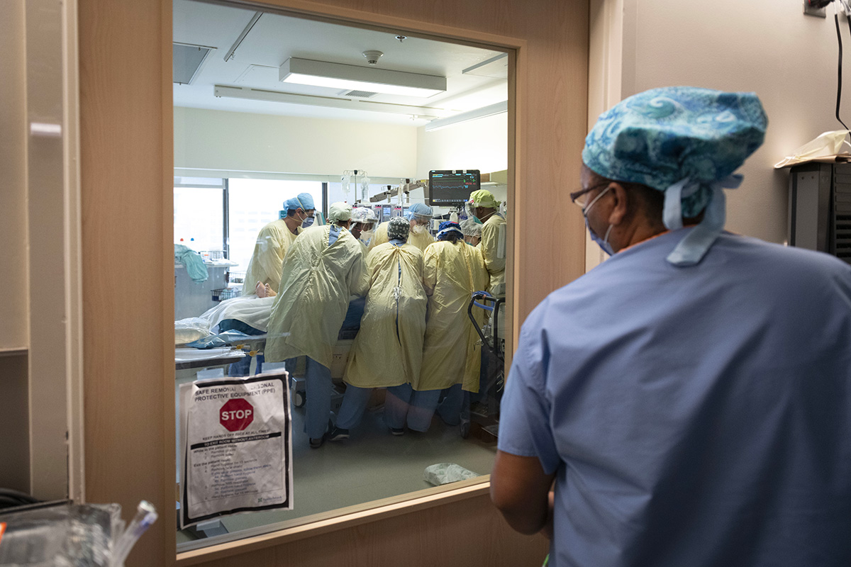 Staff in the COVID unit prepare to reposition a patient