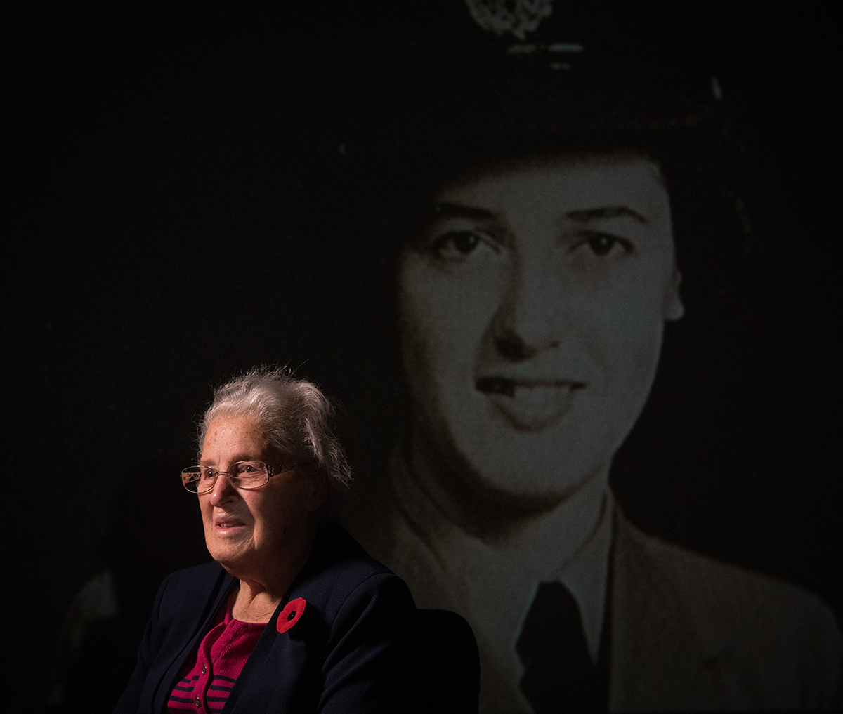 Isobel Montgomery, sits in front of a projected image of herself during the war times