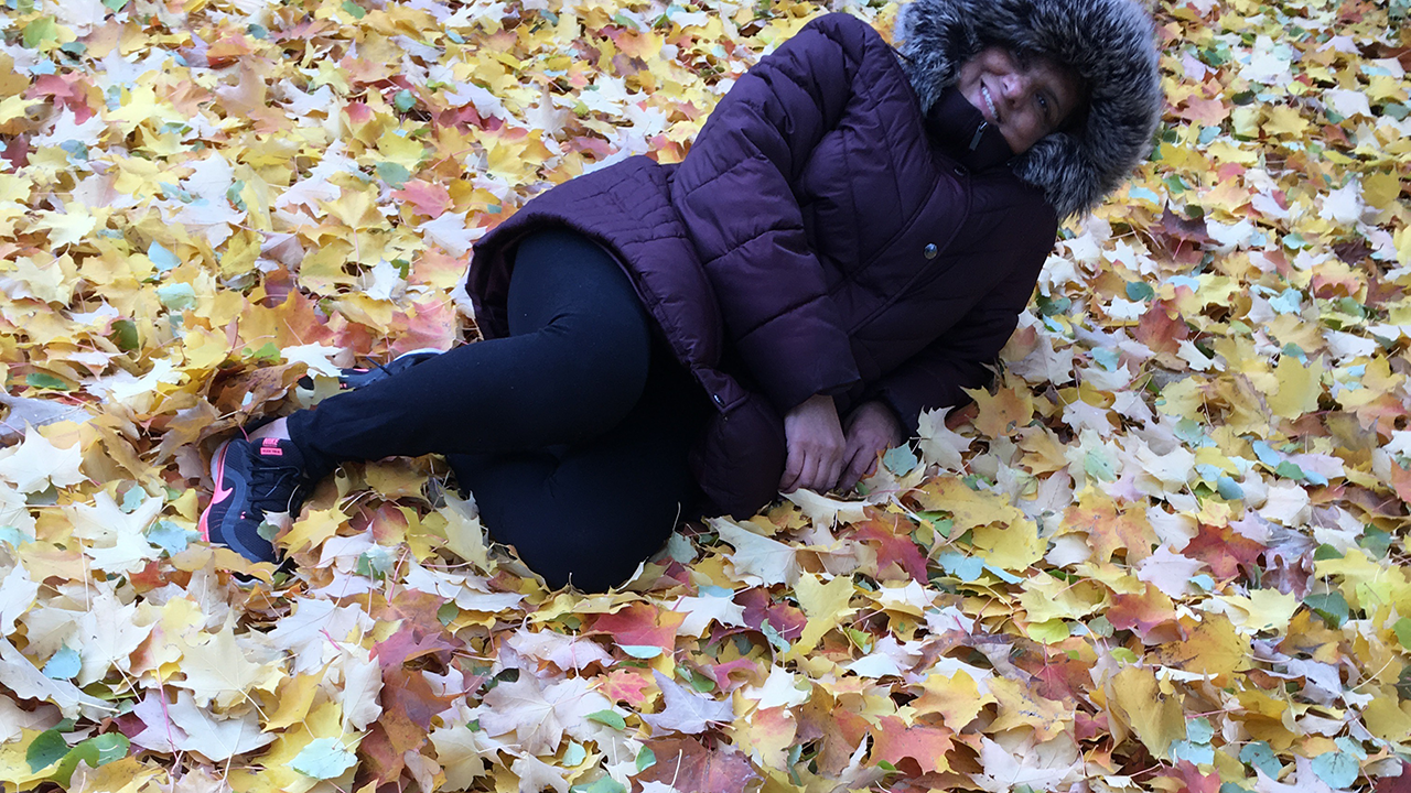 Karima laying in fall leaves