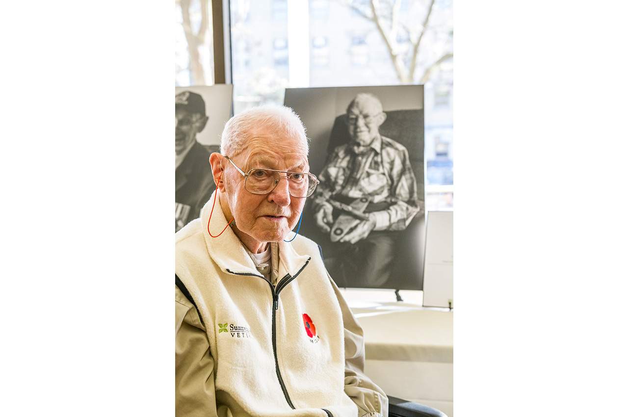 A Veteran poses with his portrait.