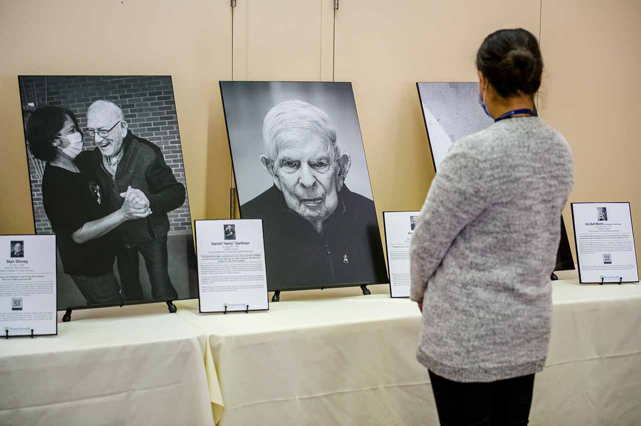 A person looks at a portrait of a veteran.