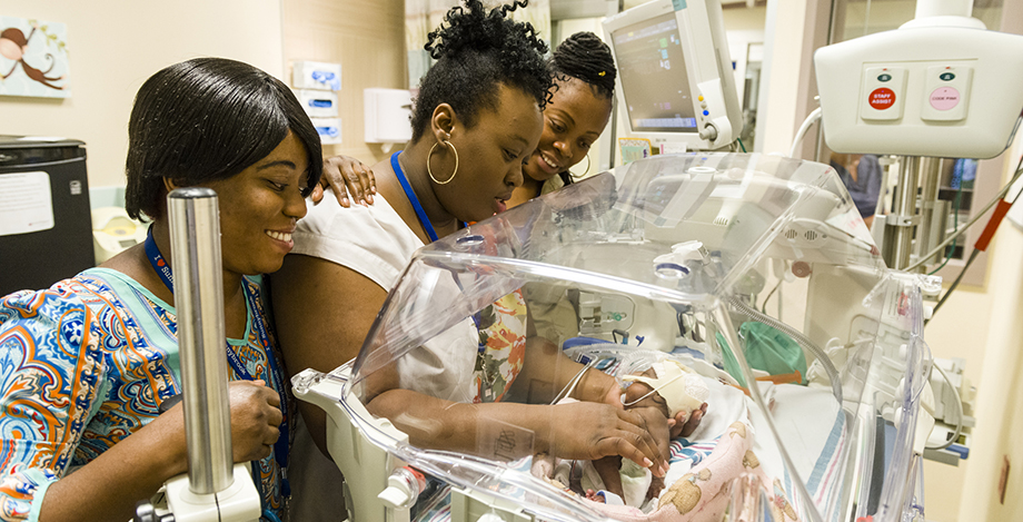 Breastfeeding counselors tending to a baby in the NICU