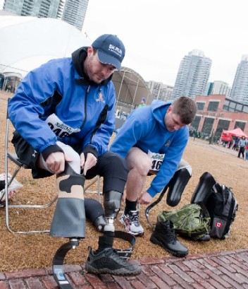 In preparation for their 5-km journey, MCpl Jody Mitic and Sgt. Jamie MacIntyre put on their customized running legs.