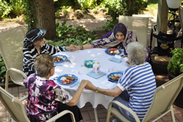 An image of four of our patients enjoying the outdoor garden and holding hands.