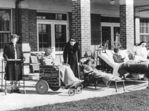 Historical image of patients convalescing in beds, wheelchairs & crutches