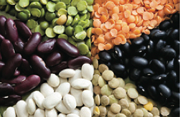 A photo of a mosaic of six different types of legumes, including split green and yellow peas, black beans, white lentils, white navy beans, and red kidney beans